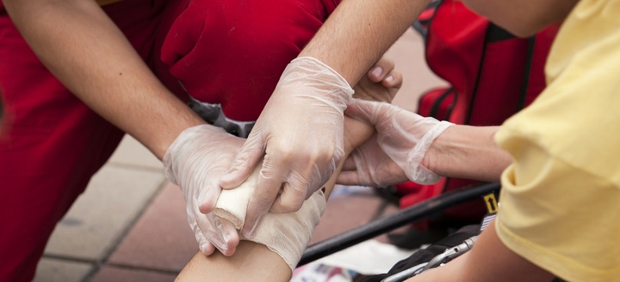 two people wearing gloves providing first aid to a casualty