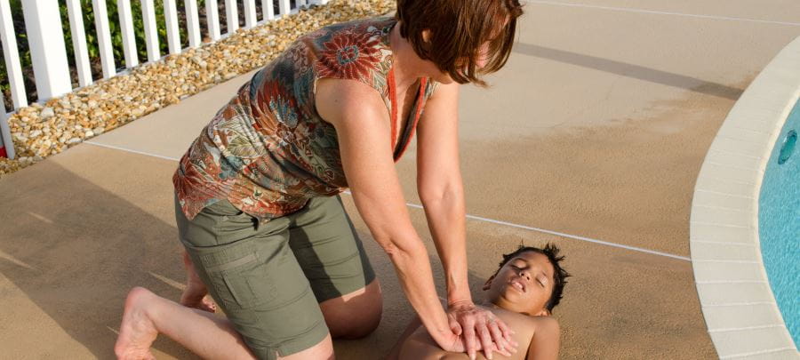 Lady giving CPR to unconscious boy