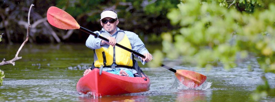 A man in a kayak paddling down a river