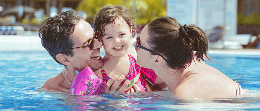 parents with their little girl in public swimming pool