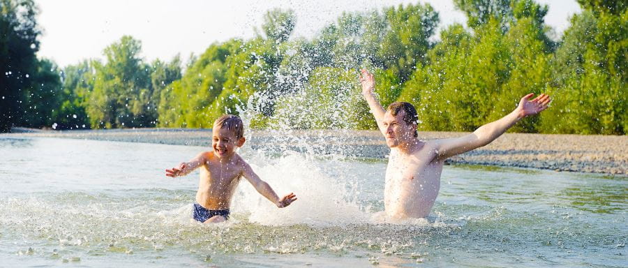 Father and son splashing in the river